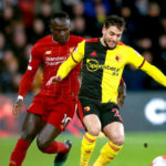 Liverpool's Sadio Mane and Watford's Kiko Femenia battle for the ball during the Premier League match at Vicarage Road, Watford.