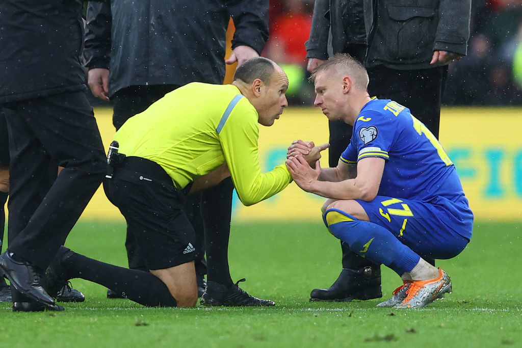 Oleksandr Zinchenko of Ukraine is consoled by referee Antonio Miguel Mateu Lahoz after their sides defeat during the FIFA World Cup Qualifier between Wales and Ukraine at Cardiff City Stadium on June 05, 2022 in Cardiff, Wales. (Photo by Michael Steele/Getty Images)