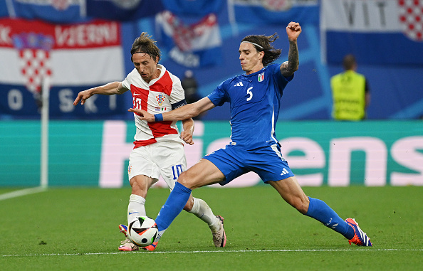 Croatia's Luka Modric challenged by Italy's Riccardo