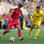 VILLARREAL, SPAIN - MAY 11: Kike Salas of Sevilla FC runs with the ball whilst under pressure from Ilias Akhomach of Villarreal CF during the LaLiga EA Sports match between Villarreal CF and Sevilla FC at Estadio de la Ceramica on May 11, 2024 in Villarreal, Spain. (Photo by Alex Caparros/Getty Images)